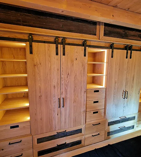 Rustikaler Einbauschrank aus Holz mit Schiebetüren im Scheunentor-Stil und integrierter Beleuchtung
