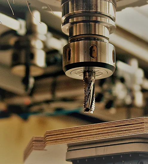 Detailaufnahme einer CNC-Fräse bei der Möbelproduktion – präzise Bearbeitung von Holzplatten