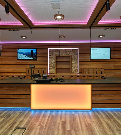 Empfangstresen mit farbiger LED-Beleuchtung und Holzfront – moderne Hotelausstattung nach Maß