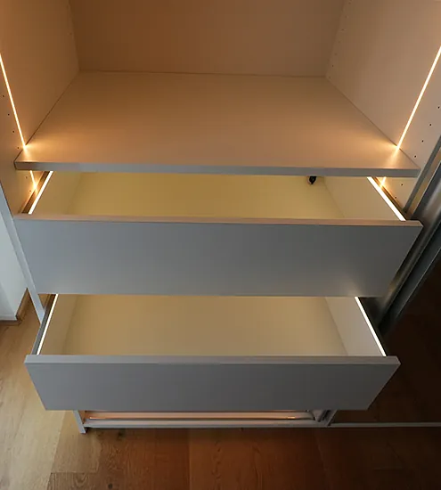 Einbauschrank mit weißen Schubladen und dezenter LED-Beleuchtung – maßgefertigte Möbel mit modernem Design.