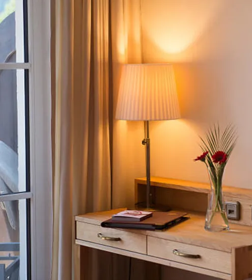 Schreibtisch mit Lampe und Vase im Hotelzimmer – handgefertigte Holzmöbel für Hotelausstattung