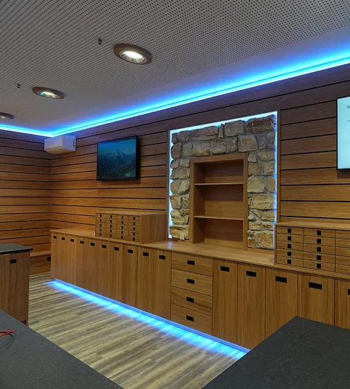 Innenausbau mit Holzverkleidung, Stein-Element und LED-Beleuchtung – moderne Objekteinrichtung