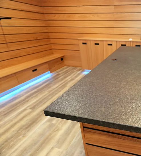 Detailaufnahme Theke mit schwarzer Steinplatte und Holzfront – individuelle Objekteinrichtung
