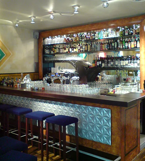 Bar mit Holzelementen und moderner Rückwand – individuelle Objekteinrichtung vom Schreiner