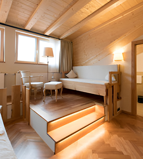 Maßgefertigte Sitzecke mit integrierter Beleuchtung und Holzverkleidung in einem Dachzimmer, gefertigt von Schreinerei Michael Heinze in Eschenlohe