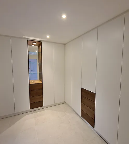 Minimalistischer Einbauschrank in Weiß mit Holzdetails und Vitrine – moderner Innenausbau