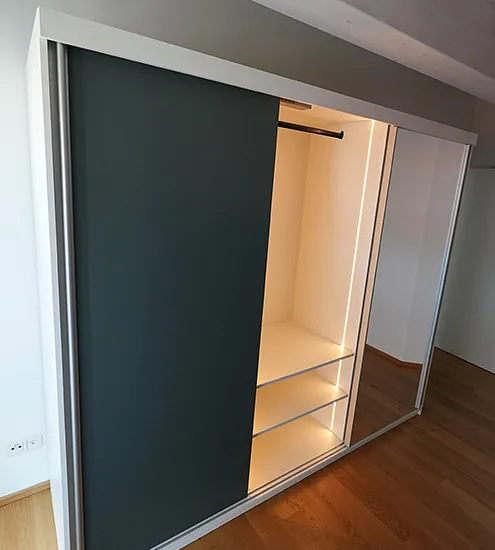 Großer Schiebetürenschrank mit dunkler Front und Spiegelfläche – platzsparende Maßanfertigung vom Schreiner.