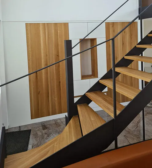 Moderne Holztreppe mit schwarzem Metallgeländer – Schreinerarbeit für Innenausbau nach Maß